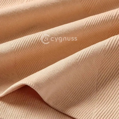 Close no tecido texturizado do short modelador Cygnuss, evidenciando a qualidade e elasticidade do material bege.